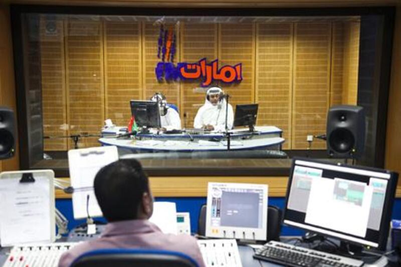 Abu Dhabi,  UAE, June 18, 2013:Studio One (better known as Studio Wahid) is a daily show, broadcast by Abu Dhabi radio. Between 10 am and noon callers can interact with the hosts and discuss issues pertaining to life in the UAE. Today's biggest topic of debate was the importance of switching to the newest government issued license plates.In the foreground is the sound engineer Nabeel Waheed, in the background are the 2 hosts of today's show Ahmed Al Mojeeny (on the left, he did not want to be recognizable in any photo) and Salem Al Kaabi (right).Lee Hoagland/The National