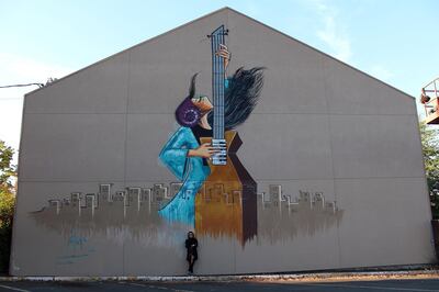 Shamsia Hassani in 2018 next to a finished mural in Eugene Oregon USA. Picture courtesy of Shamsia Hassani 