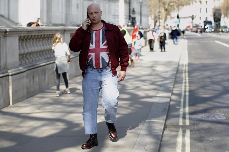 A lone Brexiteer talks on his phone as he makes his way down Whitehall in central London on March 29, 2019. MPs are set for a momentous third vote today on Prime Minister Theresa May's Brexit deal, which could end a months-long political crisis or risk Britain crashing out of the EU in two weeks. / AFP / Tolga AKMEN
