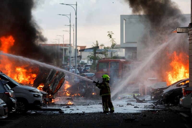 An emergency worker fights fire after rockets launched from the Gaza Strip hit Israel. Reuters
