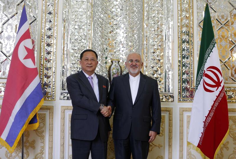 Iran's Foreign Minister Mohammad Javad Zarif (R) shakes hands with North Korea's Foreign Minister Ri Yong Ho during their meeting in the capital Tehran on August 7, 2018. / AFP PHOTO / ATTA KENARE