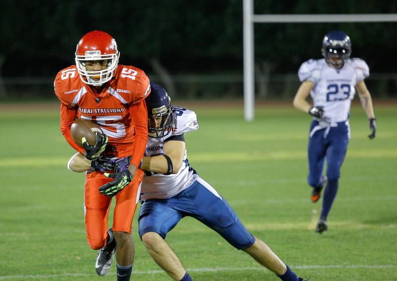 The Dubai Barracudas, in white and blue, were not able to stop the Dubai Stallions in the EAFL title game last night. Victor Besa for The National

