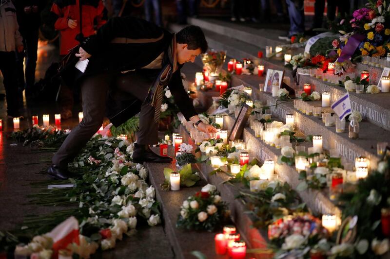 epa06398877 A visitor places a candle at the memorial on the day of commemorative events marking the first anniversary of the terrorist attack on Christmas market at Breitscheidplatz in Berlin, Germany, 19 December 2017. On 19 December 2016, Breitscheidplatz square in Berlin was the target of a terror attack in which 12 people lost their lives, when a truck driven by Anis Amri plowed through the Christmas market near the Kaiser-Wilhelm-Gedaechtniskirche (Kaiser Wilhelm Memorial Church).  EPA/OMER MESSINGER