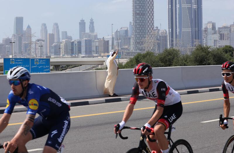 Sheikh Mohammed bin Rashid, Vice President and Ruler of Dubai, greets cyclists during the sixth stage of UAE Tour in Dubai on Friday. AFP