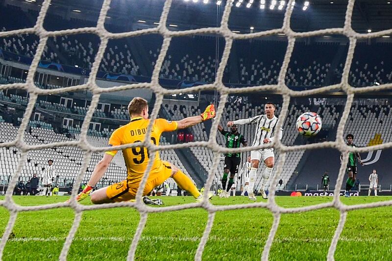 Juventus' Portuguese forward Cristiano Ronaldo (R) sccores an equalizer past Ferencvaros' Hungarian goalkeeper Denes Disbusz (L) during the UEFA Champions League Group G football match Juventus vs Ferencvaros on November 24, 2020 at the Juventus stadium in Turin. (Photo by Miguel MEDINA / AFP)