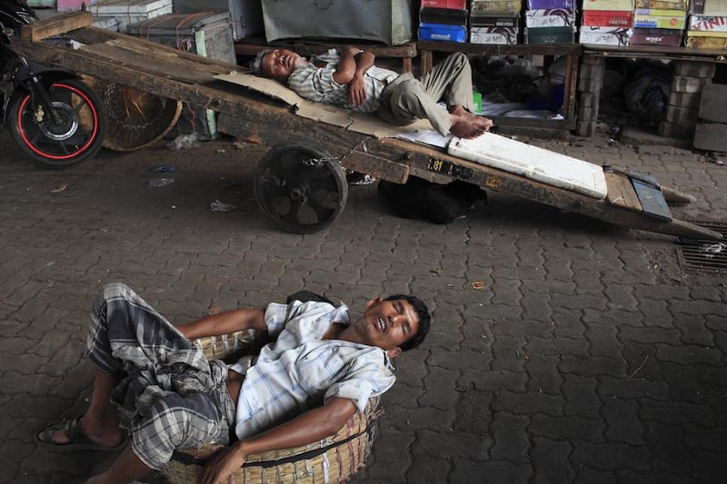 Porters take a nap while business is slow at Crawford Market. Subhash Sharma for The National