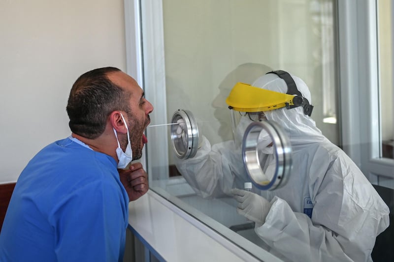 A health worker collects a swab sample from another health worker at the Istanbul University Cerrahpasa medical faculty hospital. AFP