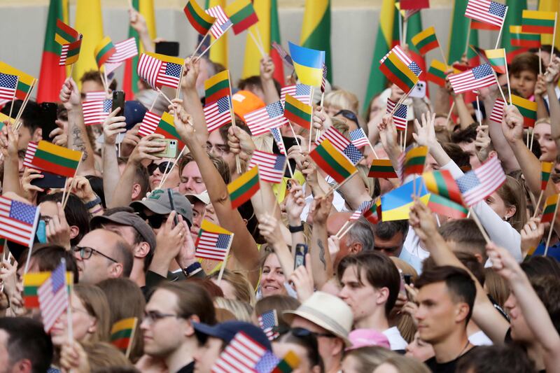 People raised US and Lithuanian flags as the US President delivered a speech. AFP