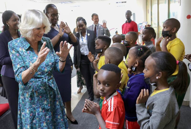 Camilla, Duchess of Cornwall, communicates with young school pupils who have impaired hearing using sign language, at Kigali Public Library. Getty Images