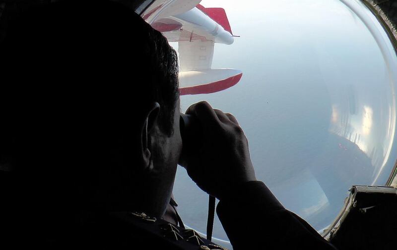 Malaysian Maritime Enforcement personnel look through binoculars during search and rescue operations. Malaysian Maritime Enforcement / AFP Photo March 9