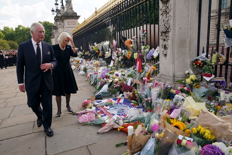 King Charles and Queen Consort Camilla view floral tributes left outside Buckingham Palace. AP