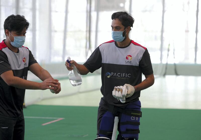 Dubai, United Arab Emirates - Reporter: Paul Radley. Sport.  Chirag Suri and Imran Haider disinfect the ball. The UAE cricket team are back at training at the ICC academy after the government have eased restrictions due to Coivd-19/Coronavirus. Sunday, June 7th, 2020. Dubai. Chris Whiteoak / The National