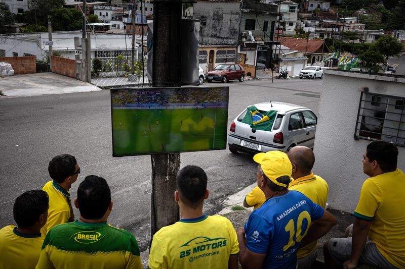 Fans watch Brazil's World Cup match against Serbia on a television fixed to a light pole, in the Brazilian city of Manaus. The South Americans won the match 2-0. EPA