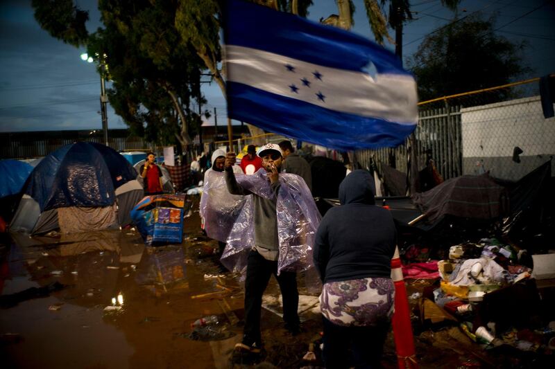 A migrant flies a Honduran flag. AP Photo