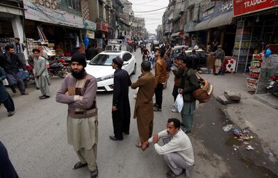 People stand outside their shops after a severe earthquake is felt in Rawalpindi, Pakistan, Wednesday, Jan. 31, 2018. A strong magnitude 6.1 earthquake rattled Pakistan and Afghanistan, including the capital cities of both countries, on Wednesday, killing a young girl and injuring five others and damaging mud-brick homes in southwestern Pakistan, officials said.  (AP Photo/Anjum Naveed)