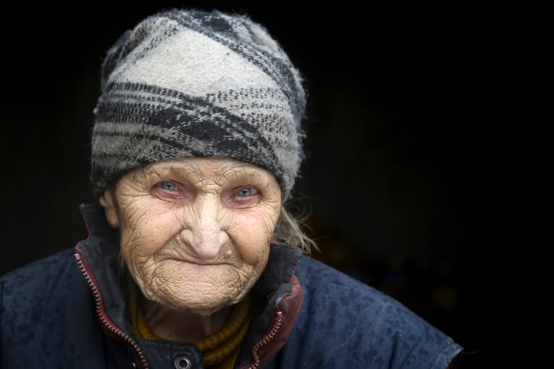 Lidia, 92, a Ukrainian who has lived here during the time of the conflict, stands at the entrance to her house in the territory controlled by pro-Russian militants, near the front line with Ukrainian government forces in Luhansk, Ukraine. AP