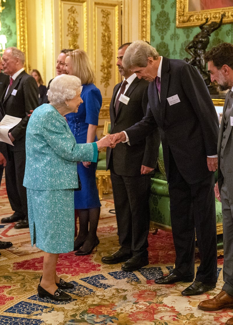 Queen Elizabeth greets US climate envoy John Kerry.