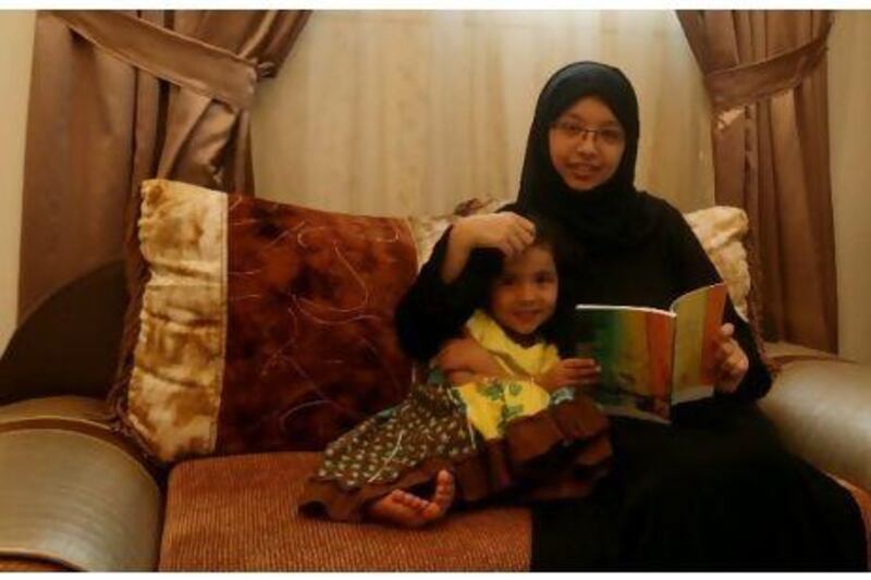 Maitha Omar sits with her younger sister Najla, with her book Nabh al Hayat (Source of Life), recently published by the Ministry of Culture, Youth and Community Development. Jumana El-Heloueh / The National