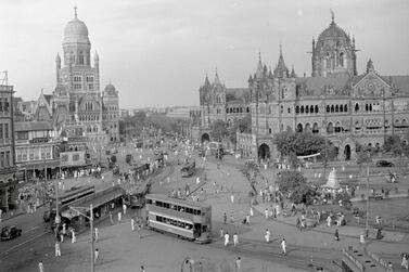 (Original Caption) Bombay, India: Municipal offices and Victoria Terminus view shows street scene with buildings and trolley cars.