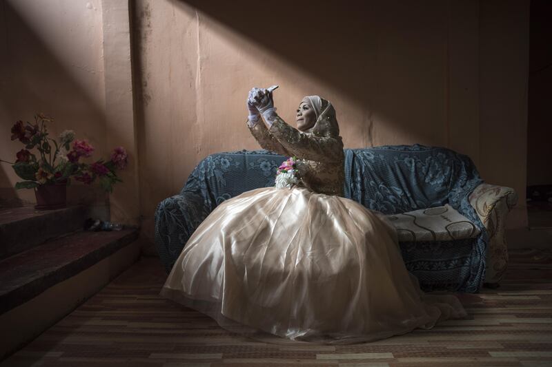 Bride Katty Malang Mikunug, takes a photo of herself in her wedding dress in Saguiaran in Lanao del Sur, southern Philippines. Jes Aznar / Getty Images