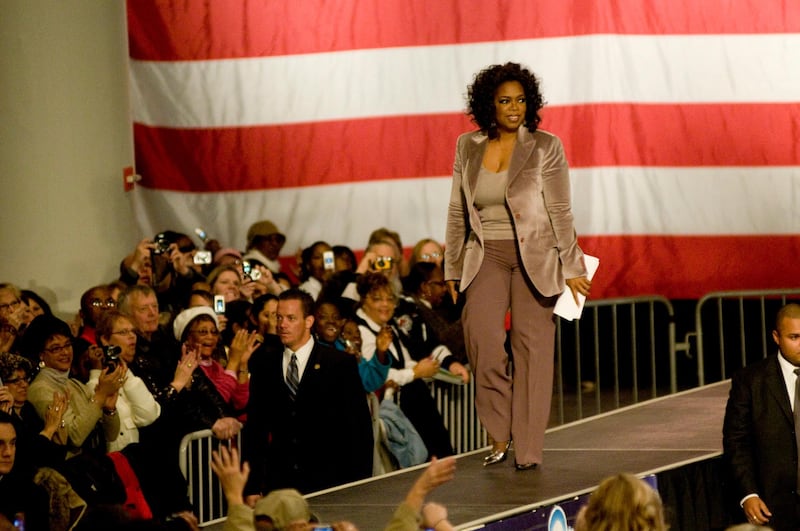 epa01195303 Television talk show host Oprah Winfrey walks onto the stage for Illinois Senator and Democratic presidential candidate Barack Obama at a campaign rally at Hy-Vee Hall in Des Moines, Iowa, USA, 08 December 2007. Obama appeared as a guest on Winfrey's show earlier in the year. This was the first stop on their three-state campaign tour.  EPA/Michal Czerwonka