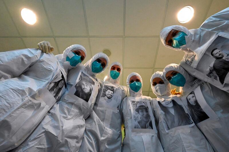 Medical workers of the Covid-19 intensive care unit (ICU) at the Santo Stefano hospital in Prato, near Florence, Tuscany, pose wearing their PPE (personal protective equipment) with photos of themselves printed on it, at the hospital in Prato.  AFP