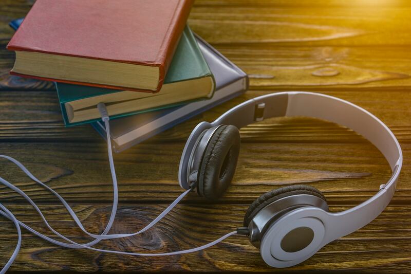 The concept is to listen to audiobooks. white headphones are connected to the book.