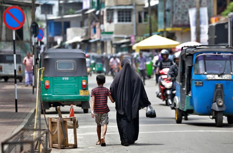 A Sri Lankan Muslim woman returns from market with her son, in Colombo, Sri Lanka, Monday, April 29, 2019. The government has banned all kinds of face coverings that may conceal people's identities. The emergency law, which took effect Monday, prevents Muslim women from veiling their faces as the Catholic Church in Sri Lanka says the government should crack down on Islamic extremists with more vigor "as if on war footing" in the aftermath of the Easter bombings. (AP Photo/Eranga Jayawardena)