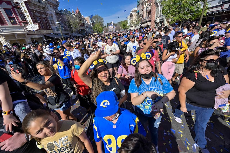 We're going to Disneyland! Los Angeles Rams fans follow players as they ride down Main Street USA during the Celebratory Cavalcade at Disneyland in Anaheim, California. AP