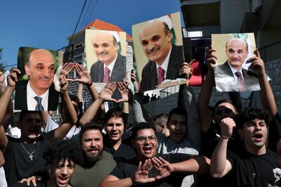 Supporters of Samir Geagea, the leader of the Christian Lebanese Forces party, chant slogans as they hold his photo after he declined to show up for questioning over deadly clashes in Beirut earlier this month, outside his residence in Maarab east Beirut, Lebanon, Wednesday, Oct.  27, 2021. AP