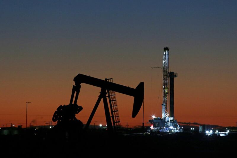 FILE- This Oct. 9, 2018, file photo shows an oil rig and pump jack in Midland, Texas. After a turbulent two months during which oil prices plummeted from a four-year high to a one-year low, investors may wonder what comes next for U.S. crude. (Jacob Ford/Odessa American via AP, File)