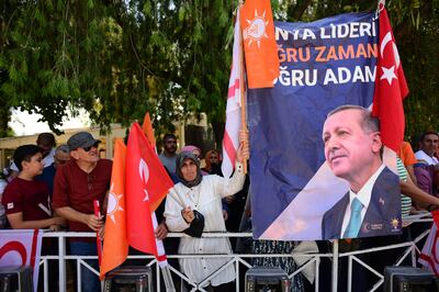 People hold a banner showing the Turkish President Recep Tayyip Erdogan. AP