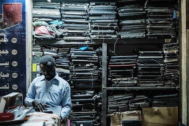 A Sudanese man repairs a laptop in front of stocks of spare parts downtown in the capital Khartoum, on December 14, 2020. The United States removed Sudan from its state sponsors of terrorism blacklist and declared a "fundamental change" in relations. AFP