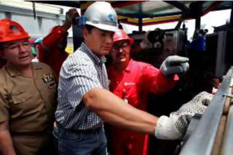 Ecuadorean president Rafael Correa turns on the first drilling rig rented by Venezuela's state-run oil company PDVSA to Ecuadorean Pertoecuador's at the Guanta 16 site in Lago Agrio, in the Ecuadorean border with Colombia, on February 21, 2008.  AFP PHOTO/Pablo COZZAGLIO