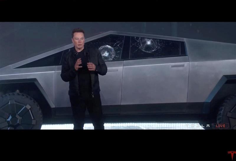 Mr Musk stands in front of Cybertruck, after a metal ball was thrown at the windows to show how tough they are. Tesla / Reuters