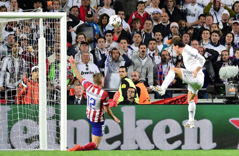 Real Madrid's Welsh forward Gareth Bale (R) scores during the UEFA Champions League Final Real Madrid vs Atletico de Madrid at Luz stadium in Lisbon, on May 24, 2014.   AFP PHOTO/ GERARD JULIEN (Photo by GERARD JULIEN / AFP)