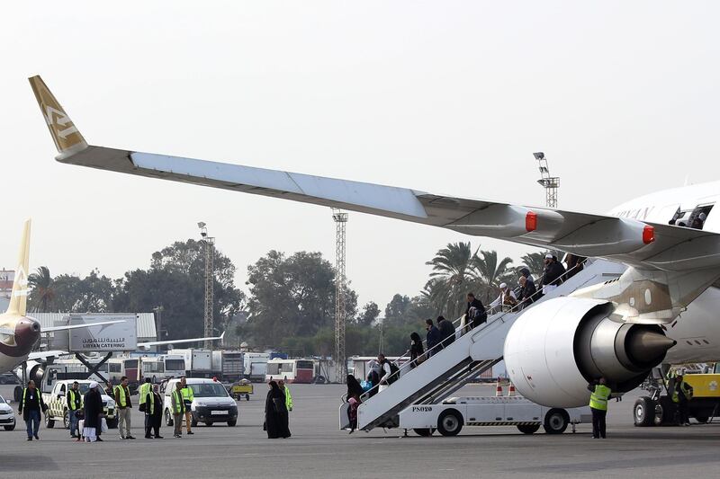 Passengers disembark from their plane after landing at Mitiga airport a few days after militiamen attacked it in an attempt to free colleagues held at a jail there, on the outskirts of the Libyan capital Tripoli, on January 20, 2018. 
The Libyan capital's only working international airport reopened today after fighting killed at least 20 people and damaged several planes earlier this week. / AFP PHOTO / Mahmud TURKIA