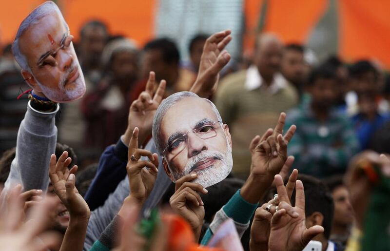 Supporters of India's ruling Bharatiya Janata Party hold up masks of Prime Minister Narendra Modi during an election campaign rally in Kathua, India. Channi Anand / AP Photo