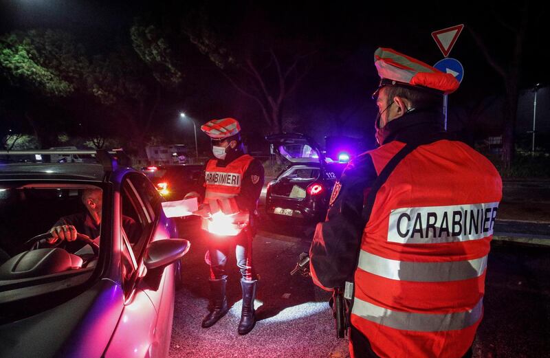 Italian carabinieri officers stop cars at a checkpoint during the curfew in Rome, Italy. EPA