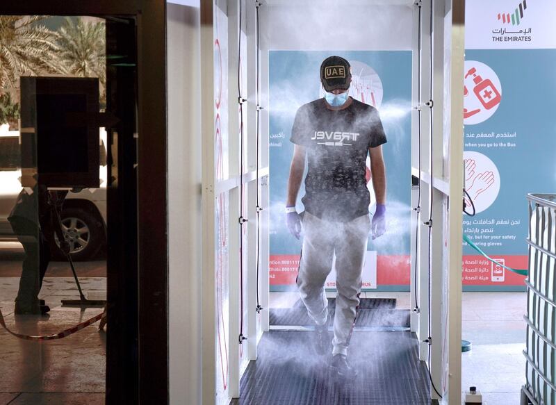 Abu Dhabi, United Arab Emirates, March 31, 2020. 
  A commuter enters the new sterilization area  and gets sprayed at the entrance of the Abu Dhabi Central Bus Terminal.
Victor Besa / The National
Section:  NA
Reporter: