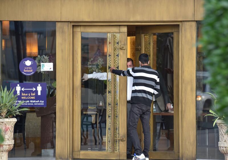 A waiter at a closed restaurant gives directions to a man in the Saudi Arabian capital Riyadh. AFP