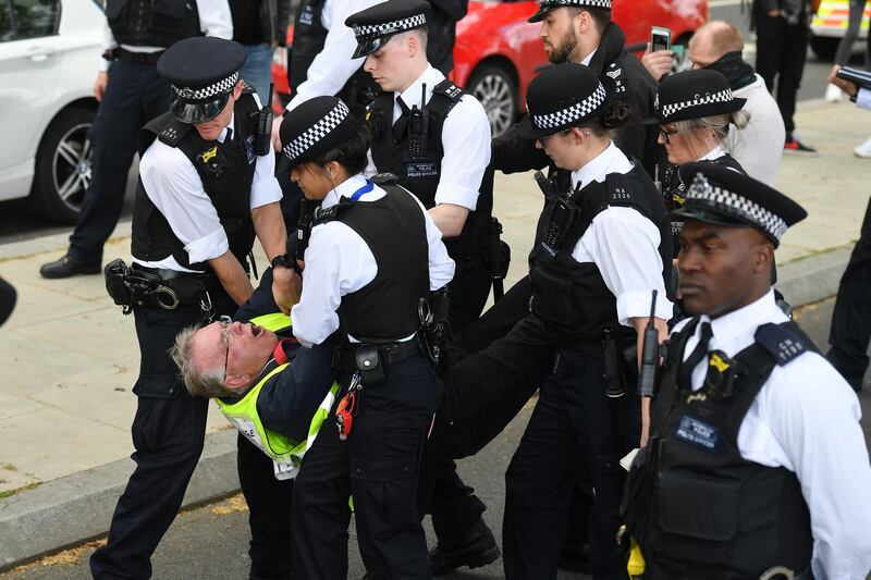 One of a small group of anti-lockdown protesters is arrested by police officers as they gather outside New Scotland Yard in Victoria, London on May 2, 2020, during the nationwide lockdown to curb the novel coronavirus COVID-19 pandemic. - Britain's overall death toll from the coronavirus outbreak rose by 739 to 27,510 on Friday, as new data indicated that people in disadvantaged areas were worse hit. (Photo by JUSTIN TALLIS / AFP)