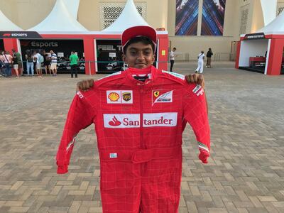Yashish Manohar shows off his signed Ferrari race suit. Charles Capel / The National