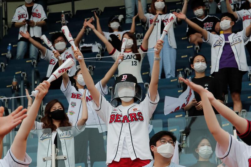 Fans wearing face masks cheer during the KBO league game between Doosan Bears and LG Twins in Seoul on Sunday. AP