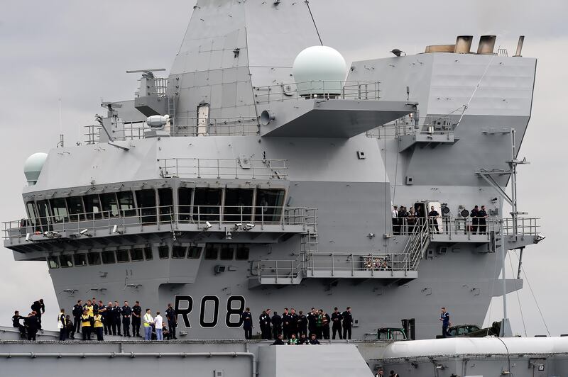 Crew stand on the decks of the 65,000-tonne British aircraft carrier HMS Queen Elizabeth on the Firth of Forth in east Scotland, on June 26, 2016, as tug boats escorted it out of its berth in Rosyth Naval dockyard to begin sea trials.
The 65,000-tonne HMS Queen Elizabeth is one of two carriers being built at a combined cost of £6.2 billion ($10.6 billion, 7.8 billion euros) to overhaul Britain's naval capabilities. The ship measures 280 metres (920 feet) long -- the equivalent of 28 London buses or nearly three times the length of Buckingham Palace -- and 56 metres from keel to masthead. / AFP PHOTO / Andy Buchanan
