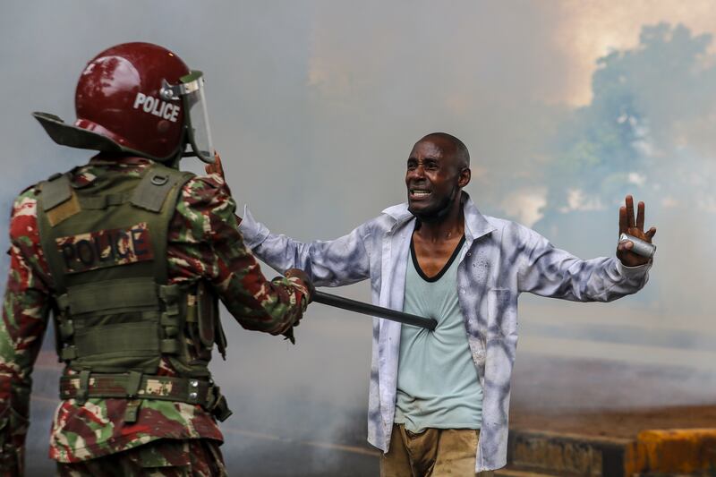 A protester surrenders to an anti-riot police officer after being overwhelmed by tear gas during demonstrations against a disputed tax bill in Nairobi, Kenya. EPA 