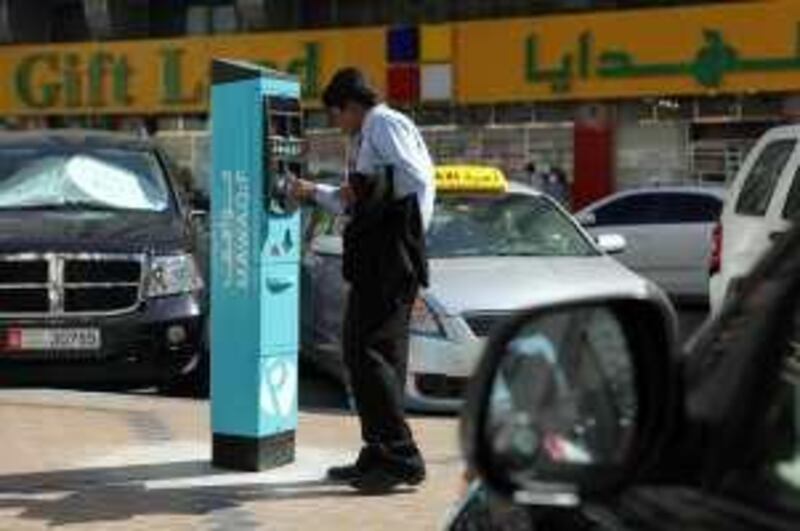 Abu Dhabi, UAE - January 30, 2010 - A taxi driver tries to figure out how to use a new parking meter on Hamdan street, next to the Home Centre. (Nicole Hill / The National) *** Local Caption ***  NH Parking02.jpg