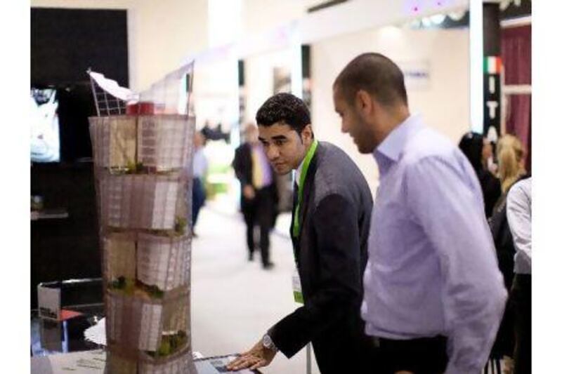 Hisham Bou Habib, right, business development manager at Livescale shows a fellow exhibitor one of Livescale's scale models.