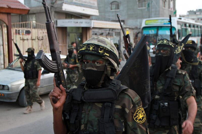 FILE - In this Oct. 2, 2012 file photo, masked militants of the Islamic Jihad group march during a rally marking the 17th anniversary of the death of the group's leader Fathi Shekaki, in Rafah Refugee camp in the southern Gaza Strip. The group was founded in 1981 with the aim of establishing an Islamic Palestinian state in the West Bank, Gaza and all of what is now Israel. It is designated a terrorist organization by the U.S. State Department, European Union and other governments. (AP Photo/Adel Hana, File)