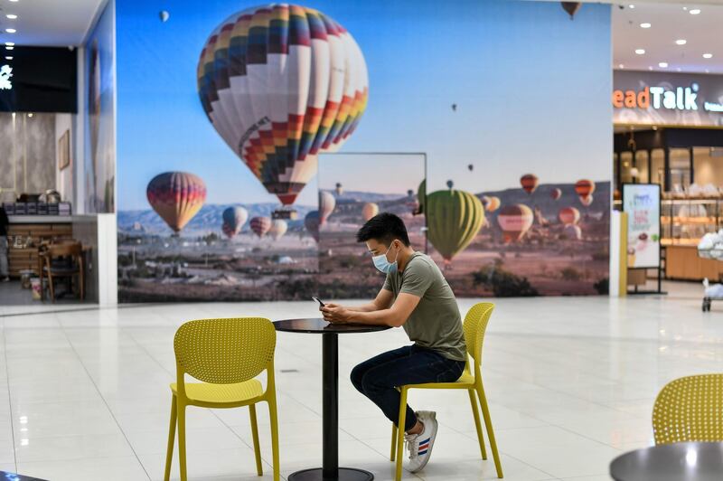 A man checks his smartphone while sitting inside a shopping mall in Hanoi. AFP